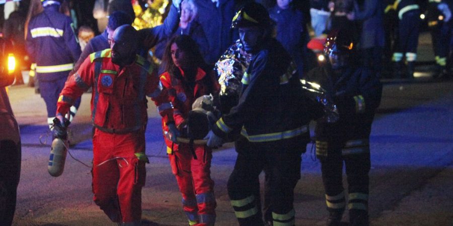 A victim of the stampede at the Italian concert is carried away for severe injuries