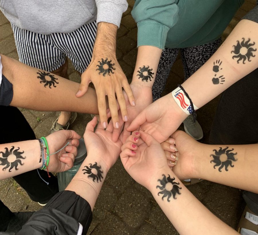  A group of students went to the airbrush tattoo station and got matching sun tattoos on their wrists.