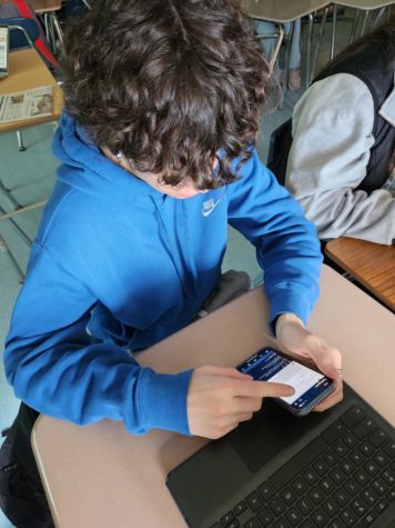 SWHS student scrolling through his social media feed in class.