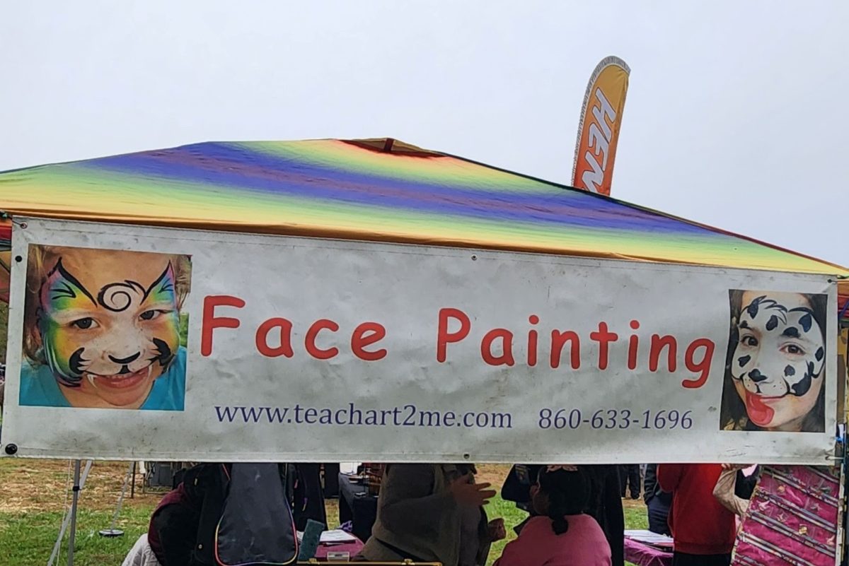 The colorful face painting tent attracts customers at Apple Fest.