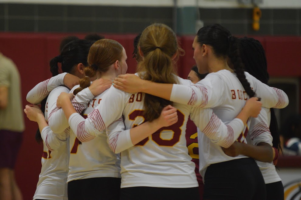 The Girls' Volleyball team in a huddle before a big game