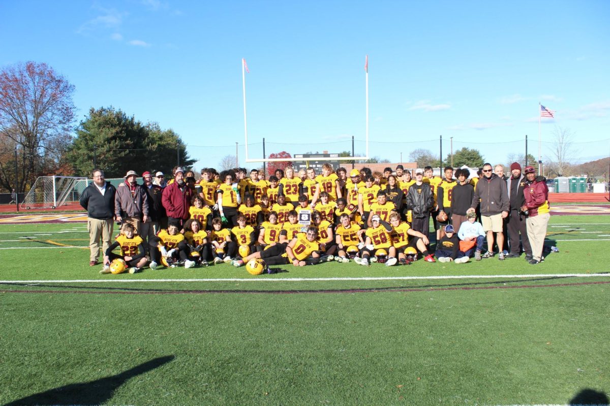 The+South+Windsor+High+School+football+team+poses+with+the+route+five+rivalry+trophy+following+the+win+vs.+Enfield.