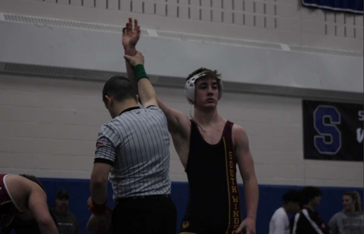 Junior Justin Dittmar celebrates after beating his opponent on the mat.
