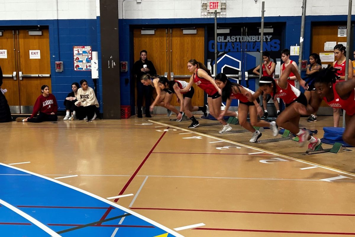 Indoor track runners lined up at the start of the race. 
