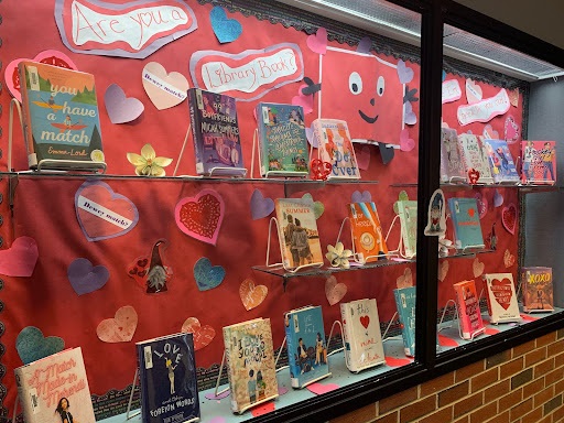 A Valentines Day themed bulletin board on display showcasing reading material.