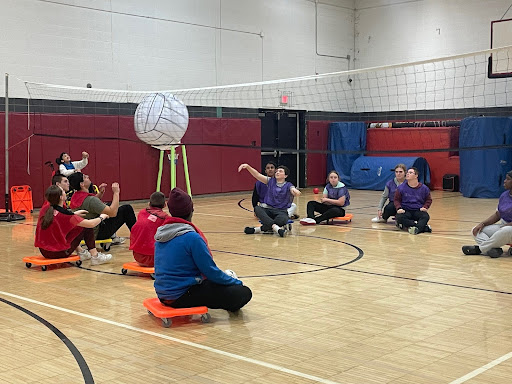 (Disabled and able-bodied students playing volleyball together during the Unified Sports class).
