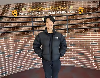 Junior Gwangsu Ethan Kim posing in front of the auditorium where he frequently performs.