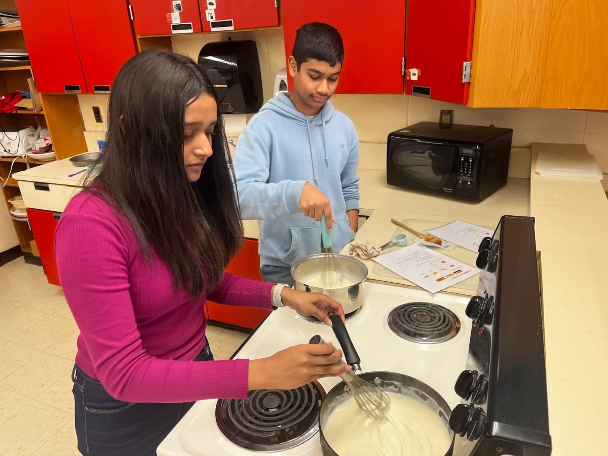 Bhaavni Krishna and Akilan Anand whipping up a soufflé au fromage (cheese soufflé)