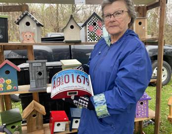 Denise Ruddy holding a homemade birdhouse that she sold at the event.