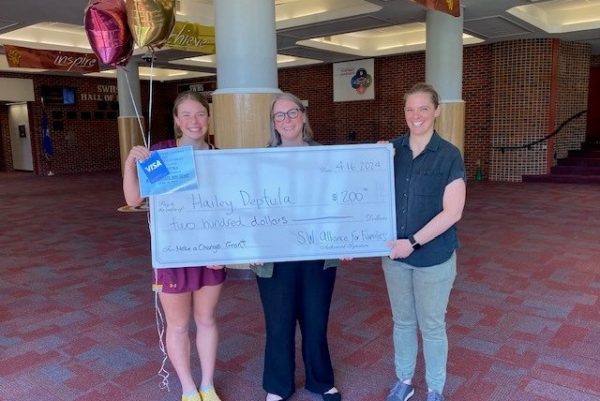Junior, Hailey Deptula, proudly holds the  Make A Change grant with SW Youth and Family Services director, Liz Langevin, and English teacher, Mrs. Flachsbart.