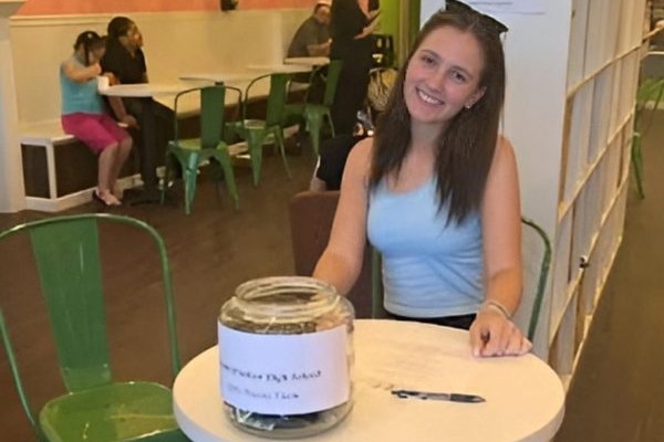 A member of the girls’ tennis team, Julia Jawarski, sitting up front and collecting donations.