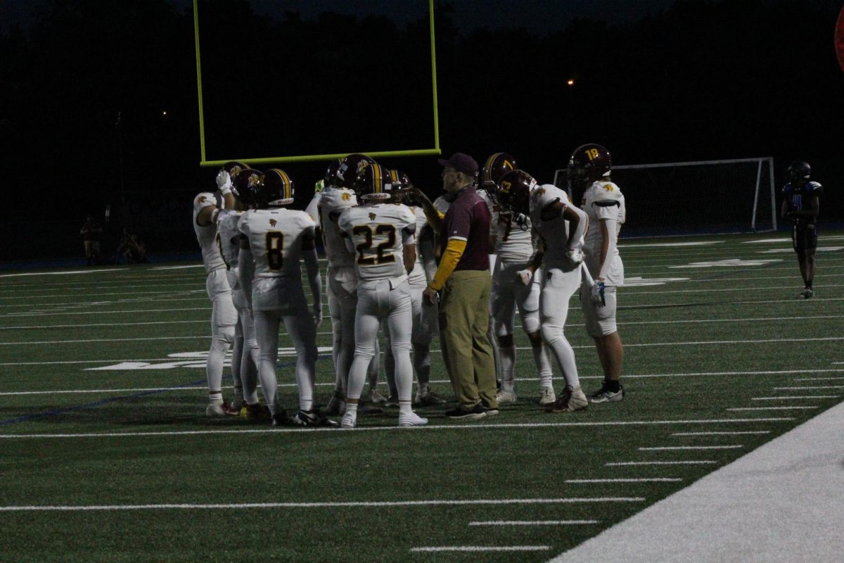 The South Windsor High School football team gathers around coach David Hodge.