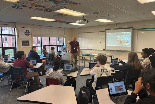 Mr. Walz, using a visual demonstration to teach his history class