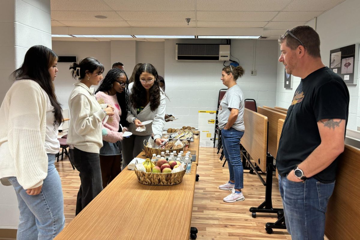 School counselors, Mr. Briggs and Ms. Wlodarczyk serve food at the new student breakfast. 