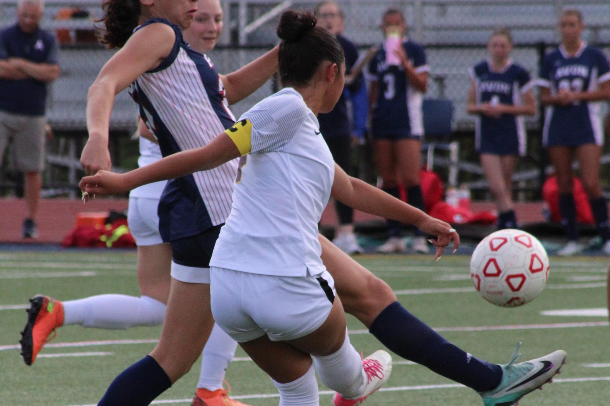 Senior varsity captain Lilah Cabahug playing center defensive mid, clears the ball. 