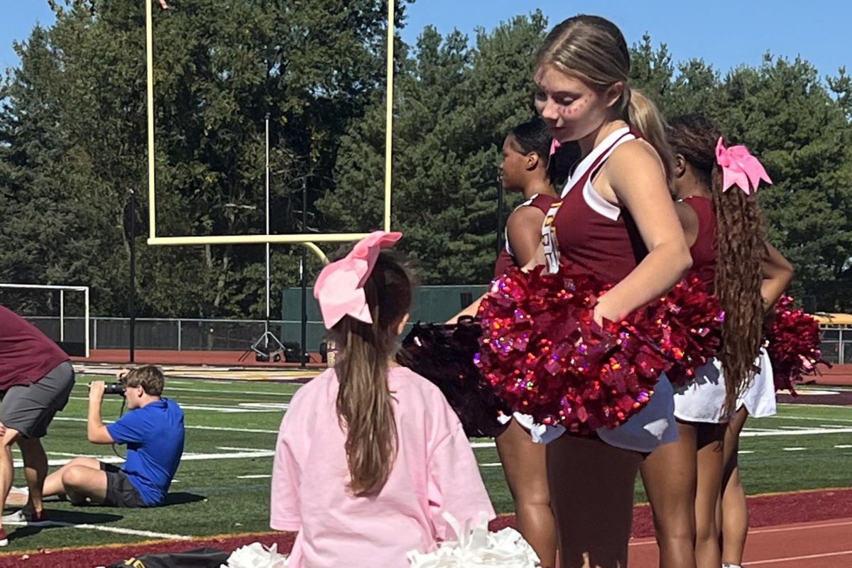 Freshman Bobcat Cheerleader Riven Dahms offers support and advice to a Panther cheerleader. (SW Cheerleaders)