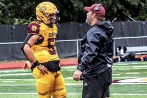 South Windsor Head Football Coach Dave Hodge motivating senior captain Nathan Tenney.