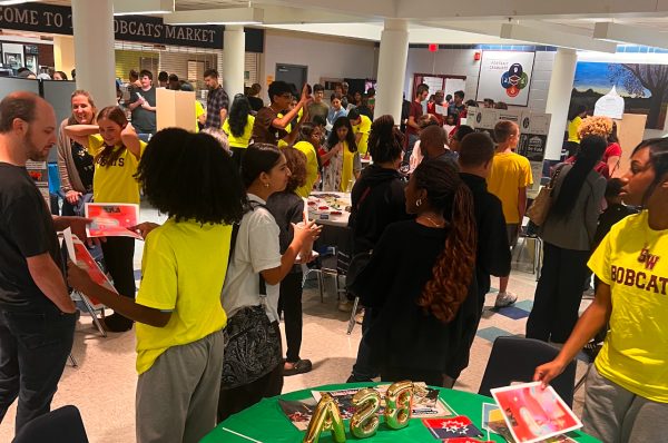 8th grade students from Timothy Edward's Middle School and their parents circulate in the high school cafeteria during 9th Grade Rising Night.