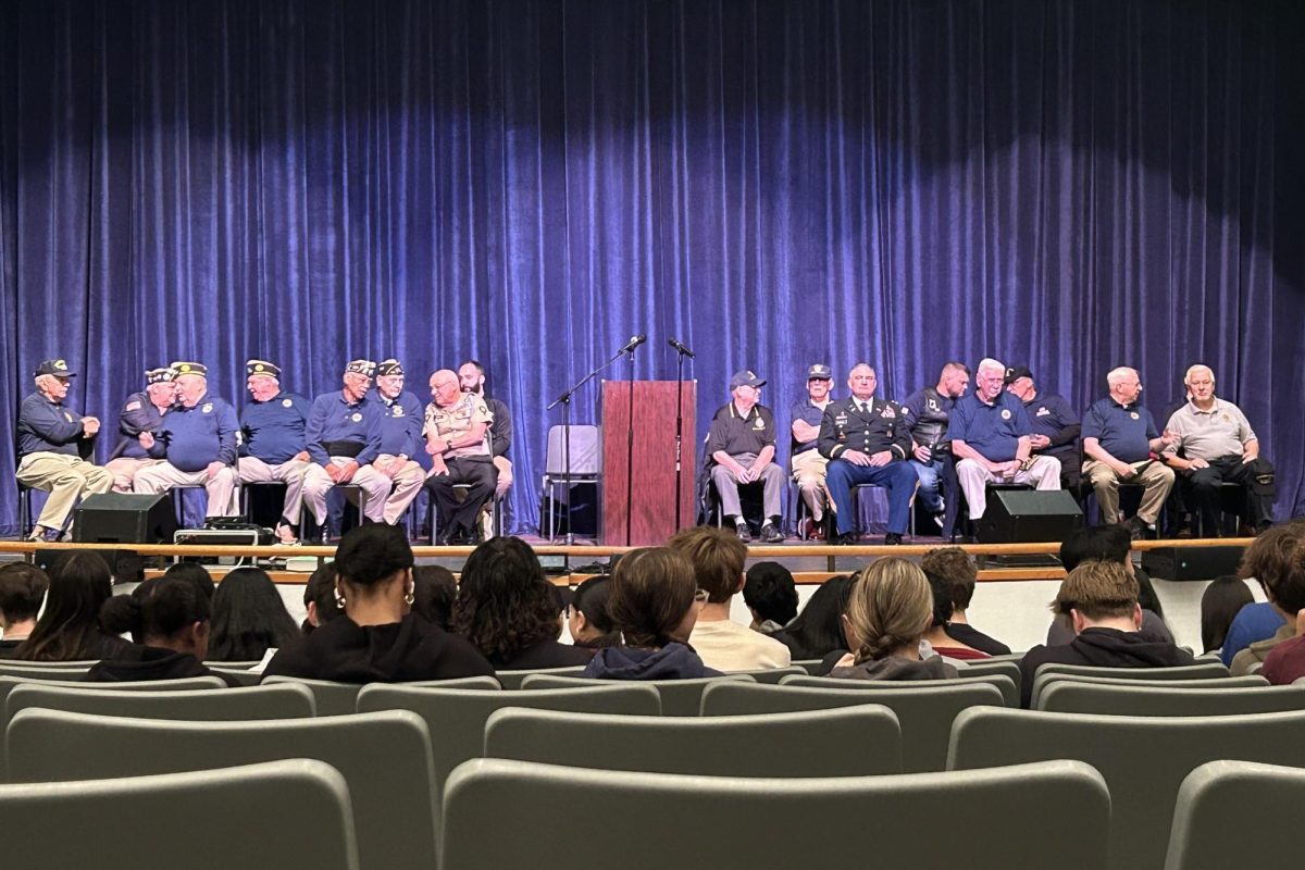 Veterans on the stage waiting for the assembly to begin. 