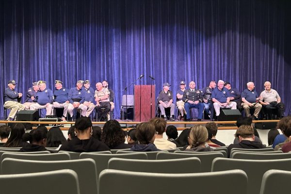 Veterans on the stage waiting for the assembly to begin. 