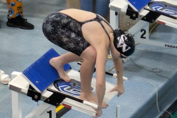 Sophomore Sara Lambert preparing to swim her 50 meter freestyle event. 