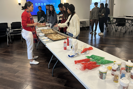 FBLA Advisor Mrs. Cruz-Penna serves sugar cookies to students for decorating.