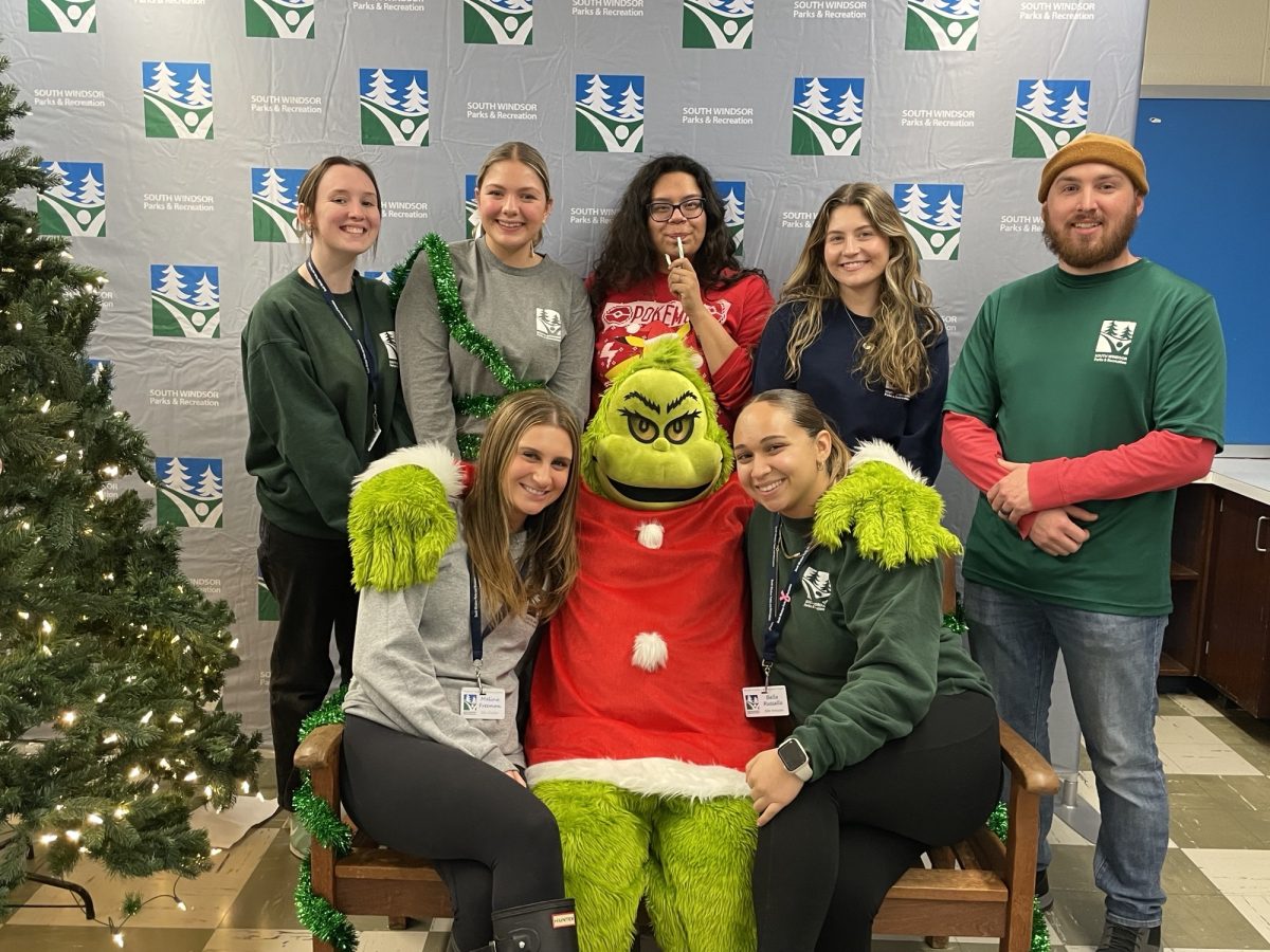 The South Windsor Parks and Recreation Department staff pose for a photo with the Grinch. (Shelby Kosa)