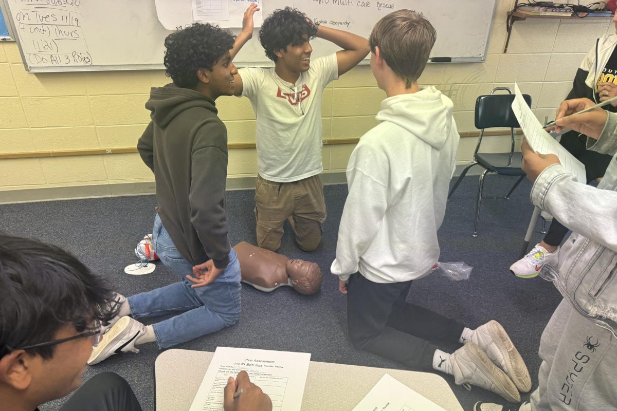 A group of students practice life-saving CPR on a child mannequin. 