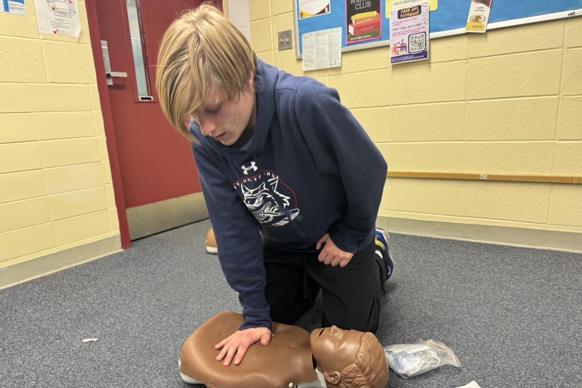 Sophomore Hunter Desmarais performing one-handed compressions on a child mannequin. 