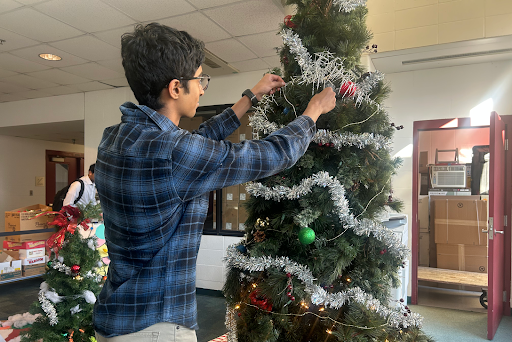 Senior NHS member Satvik Kadappanavar putting an ornament on the Christmas tree set up at the pendulum. 
