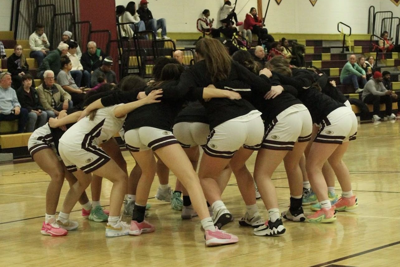 The South Windsor High School Girls Varsity Basketball Team in a huddle fostering team spirit. (Angelica Ruiz)