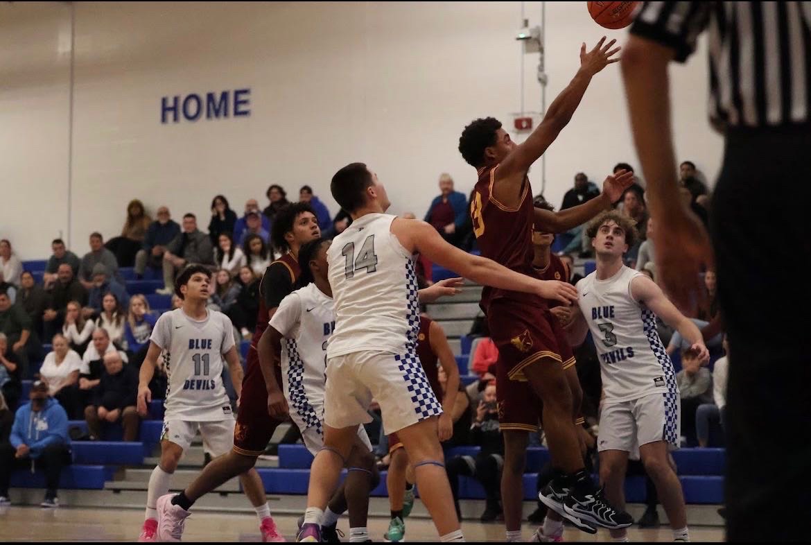 Junior guard, number 13, Jaden Bridgeforth, driving to the rim through Plainville's defense.