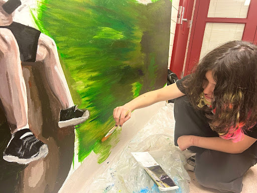 A student in Mrs. Argenta's art class working on the summer mural. The summer painting will be displayed in the cafeteria this spring.