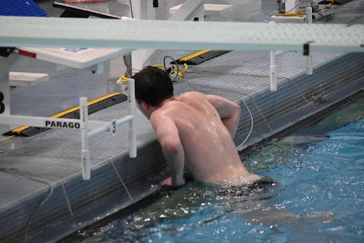 Senior Boys’ Varsity Swim Captain Dylan Baumgartner exits the swimming pool after performing a dive. (Nathan Baumgartner)