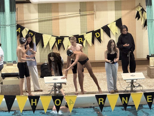 Senior Aditya Patel high fives his teammate during the meet on February 4th. (Maansi Patel)
