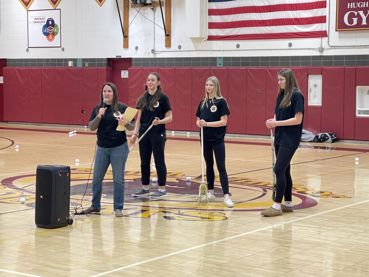 President of the lacrosse association, Caitlin Cincotta, introduces seniors Mady Syme, Elise Suffish, and Kaitlyn Bullock during lacrosse opening night. 