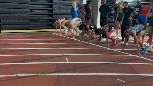 Girls lined up ready in the set position awaiting the gun to go off. 