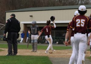 Senior Robert Wunsch touches home plate after hitting his first career home run against Lewis Mills.
