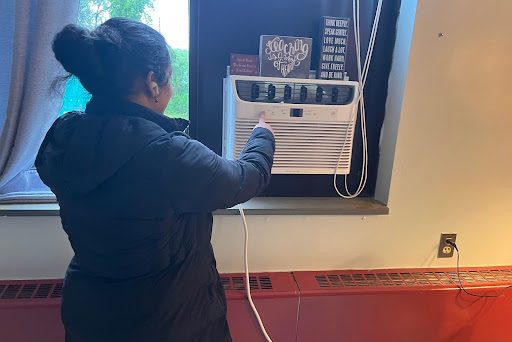 Student at South Windsor High School turns on the air conditioner to regulate air flow in a classroom.  