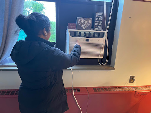 Student at South Windsor High School turns on the air conditioner to regulate air flow in a classroom.  