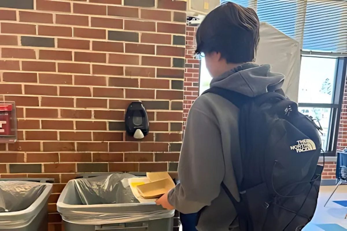 A South Windsor High School student throws away his trash at lunch.