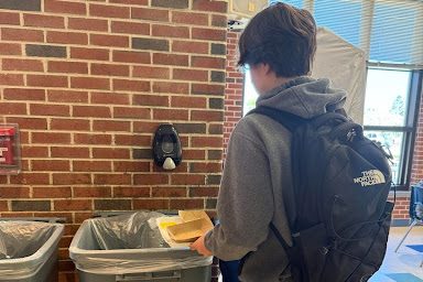 A South Windsor High School student throws away his trash at lunch.