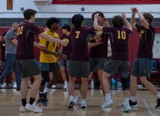 Members of the boys’ volleyball team celebrate after earning a point off a block.  (Junayd Sebro)
