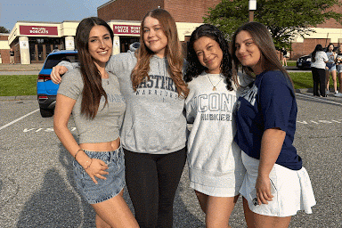 Seniors Kyra Soucy, Victoria Davies, Sophia Ghagare, and Emma Cherubini pose for a photo in front of the school in the senior lot for decision day.