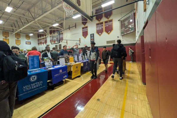 Students walking around and stopping at each college table getting information to decide where they want to go after graduation. 