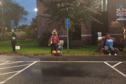 These three scarecrows are located on the green lawn on the front of the South Windsor Public Library. Audrey is the black scarecrow on the left, Sunny is the red scarecrow on the center, and Vacation Day is the blue scarecrow on the right.
