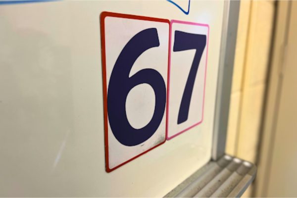 Magnetic table numbers stuck to Mrs. Devassy’s whiteboard in the math wing at South Windsor High School which students have arranged in a 6-7.