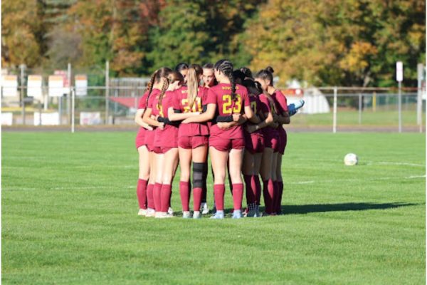 South Windsor Girls Varsity Team huddling before a game to discuss tactics and focus on the start of the game.