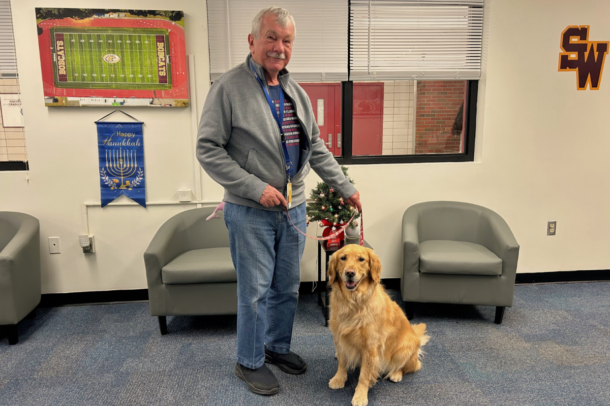 Dayton Stimson and his golden retriever Eve In the main office in front of a mini Christmas tree