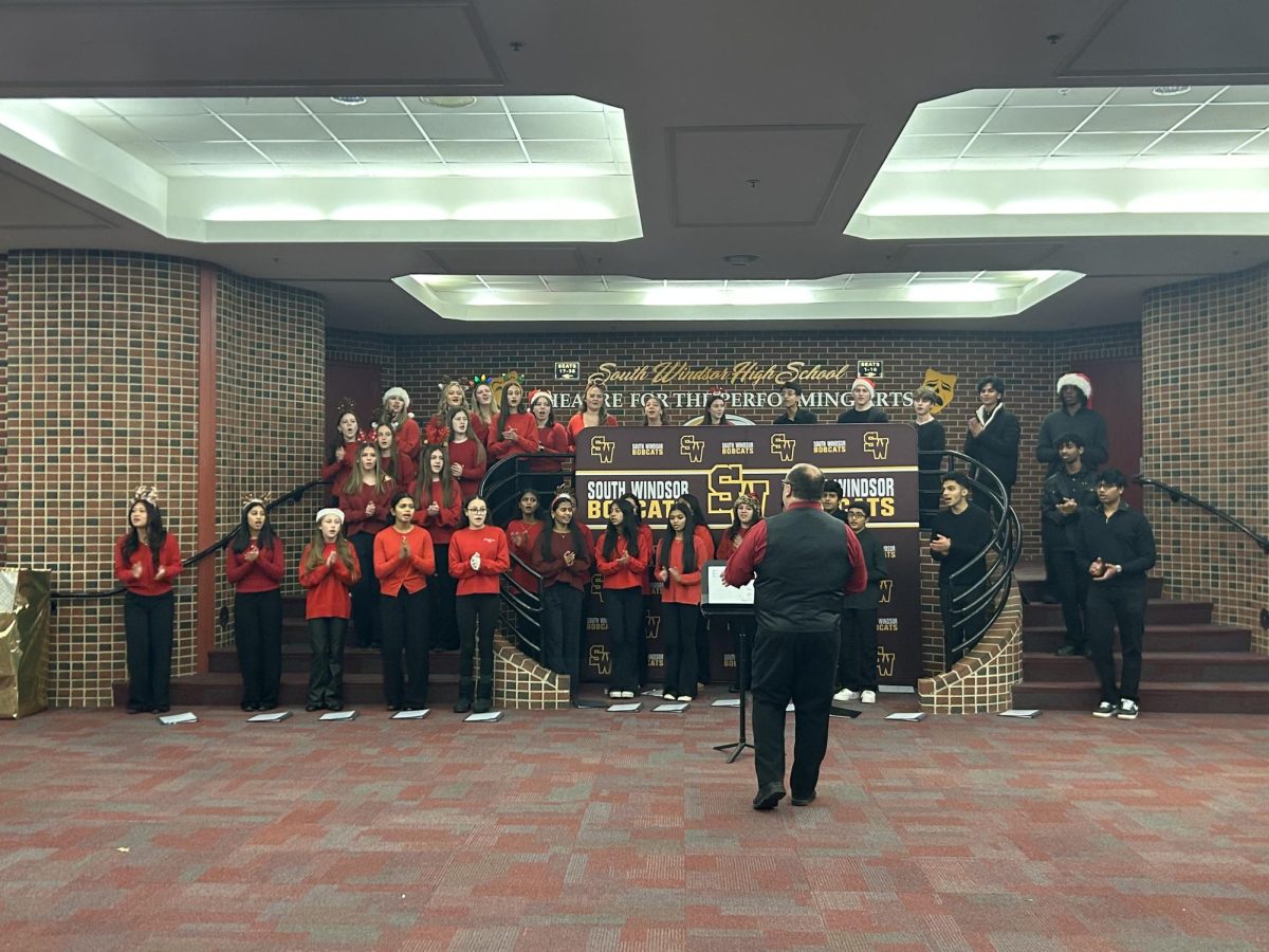 Mr. Martineau leads Choral Spectrum in their annual caroling in the halls. 